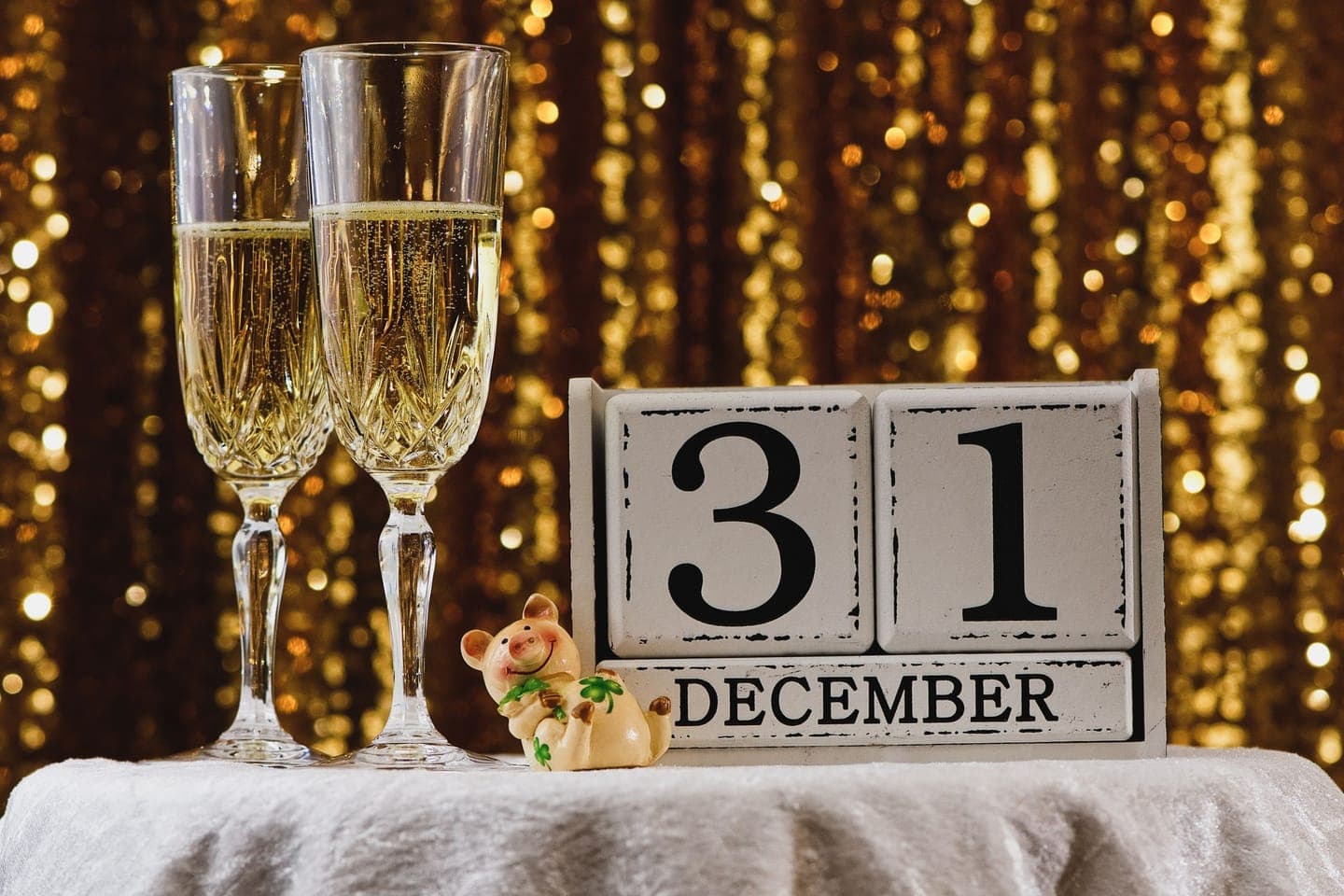 Two glasses of champagne beside a calendar showing 31 December